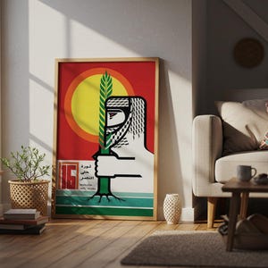 May include: A rectangular framed poster featuring a stylised graphic of a person wearing a keffiyeh, holding a green wheat stalk against a large yellow sun and red background. The bottom includes the text 16 and Arabic script in black.