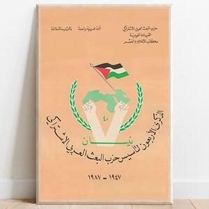 May include: A rectangular poster with a light orange background featuring a central graphic of two raised fists holding a green map and a flag with black, white, green, and red colours. The design includes a green laurel wreath and Arabic text.