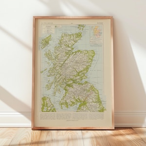 Könnte beinhalten: Eine gerahmte Vintage-Karte von Schottland mit detaillierten geografischen Informationen. Die Karte ist hauptsächlich grün und beige, in einem Holzrahmen. Sie lehnt an einer weißen Wand auf einem Holzboden, mit Schatten.