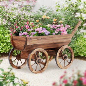 May include: A rustic wooden wagon planter filled with vibrant pink, purple, and yellow flowers. The wagon has four spoked wheels and a handle, perfect for a garden or outdoor space. The wood has a natural finish.