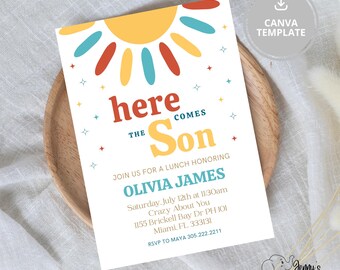 May include: A white invitation card with a colorful sun design and the text "Here Comes the Son." The invitation includes details for a lunch honoring Olivia James, with date, time, and location information. The card is on a wooden plate.