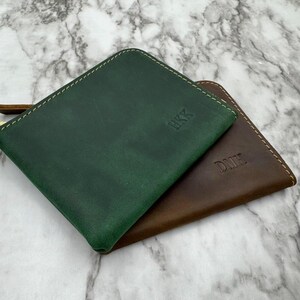 Puede incluir: Se muestran dos carteras de cuero, una verde bosque y otra marr&oacute;n. La cartera verde tiene grabado "HKK", mientras que la marr&oacute;n tiene "DMH". Ambas tienen costuras color crema en los bordes.