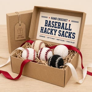 May include: A gift box containing five hand-crocheted baseball hacky sacks in various colors, including white, cream, and black, with red and white stitching. The box includes a tag that says "Great Gift Idea".