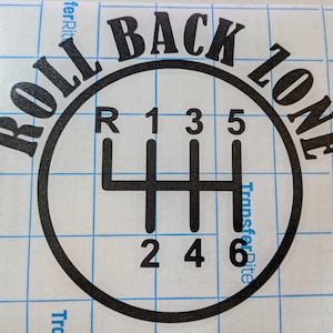 May include: Black and white graphic of a car's manual transmission gear shift pattern. The text "ROLL BACK ZONE" arcs around the top of the circle. Numbers and letters indicate the gear positions.