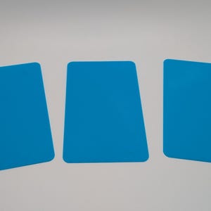 Op de afbeelding: Drie felblauwe rechthoekige objecten met afgeronde hoeken zijn gerangschikt op een witte ondergrond. De objecten zijn gelijkmatig verdeeld en hebben een effen, plat uiterlijk. De kleur is een levendig, effen blauw.