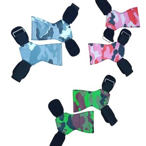 May include: Five weightlifting wrist wraps in various camouflage patterns. The wraps feature black wrist straps and buckles. The camouflage patterns include shades of blue, pink, red, and green.