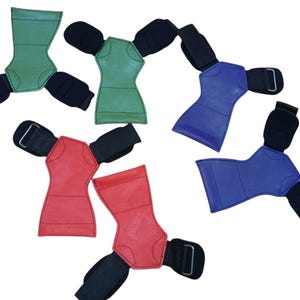 May include: Assortment of weightlifting grip pads in green, red, and blue. Each pad has a contoured shape with a black wrist strap and a hook-and-loop closure for secure grip during workouts. The pads are designed to protect hands and improve grip.