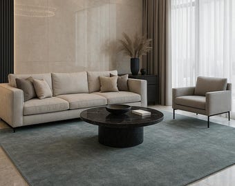 May include: A modern living room with a neutral color palette. Features include a beige sofa with throw pillows, a dark marble coffee table, a gray armchair, and a large area rug. A circular chandelier hangs above the seating area.