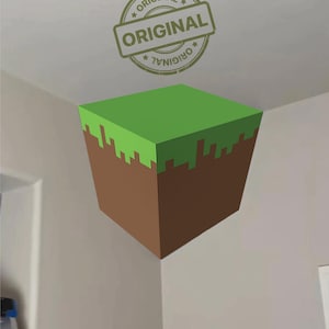 Puede incluir: Un bloque al estilo Minecraft con una parte superior de hierba verde y lados de tierra marrón. La palabra "ORIGINAL" está estampada encima del bloque en un diseño circular.