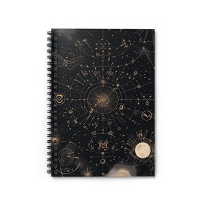 May include: A black spiral-bound notebook with a gold celestial design. The cover features constellations, zodiac symbols, and a full moon illustration. The notebook is held together by a silver spiral binding.
