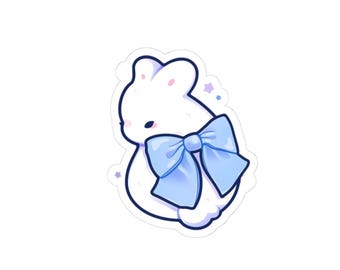 May include: A white bunny sticker with a large, light blue bow. The bunny has a simple, cartoonish design with a black outline. Small purple stars are scattered around the bunny.