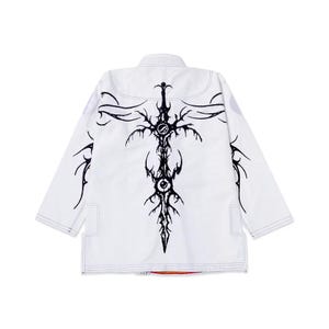 Può includere: Uniforme bianco di arti marziali con un sorprendente design grafico nero sul retro. Il design presenta un intricato motivo a spada o croce stilizzata. L'uniforme ha un taglio tradizionale con cuciture rinforzate.
