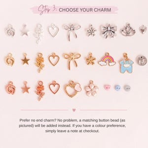May include: A selection of charms in various shapes, including stars, hearts, flowers, bows, and a rainbow. The charms are in silver, gold, and rose gold tones. The text "Step 3: CHOOSE YOUR CHARM" is at the top.