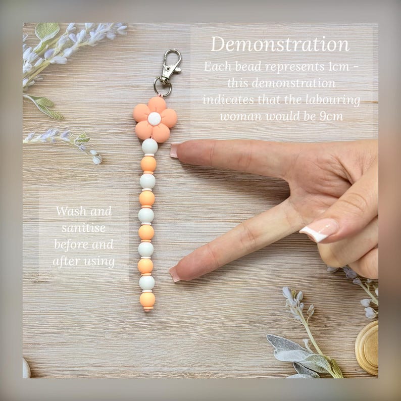 May include: A beaded keychain with a flower-shaped top in peach and white. The keychain has a silver clasp and a series of peach and white beads. The text on the image says "Demonstration" and "Wash and sanitise before and after using."