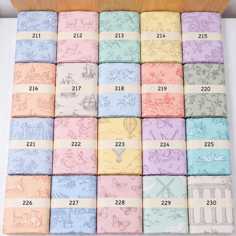 Op de afbeelding: Een collectie van twintig gevouwen stofstalen gerangschikt in een raster, elk met een uniek toile de jouy-patroon in diverse pastelkleuren. Elke staal is vastgezet met een papieren band voorzien van een nummer van 211 tot 230.