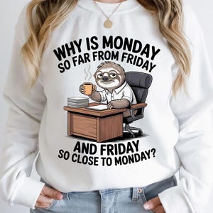 May include: White sweatshirt featuring a cartoon sloth wearing glasses, holding a coffee cup, and sitting at a desk. The text reads, "WHY IS MONDAY SO FAR FROM FRIDAY AND FRIDAY SO CLOSE TO MONDAY?" The sloth is in an office setting.