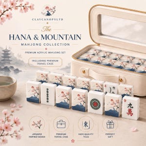 May include: A premium acrylic mahjong set titled The Hana & Mountain Mahjong Collection by Claycanopyltd. The set includes white tiles featuring cherry blossom and mountain illustrations, along with a cream-colored travel case with a clear lid.
