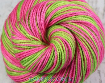 May include: A vibrant skein of yarn in a spiral pattern, featuring alternating stripes of bright pink and lime green. The text "SAMPLE ONLY. Colors may vary due to fiber content" is visible at the bottom.