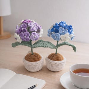 Puede incluir: Un letrero de madera hecho a mano con el texto "Welcome to our home" en un estilo manuscrito. El letrero está pintado de blanco con un acabado envejecido y presenta un borde negro. Un pequeño corazón decorativo está adjunto en la parte inferior.