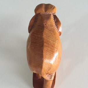 May include: A wooden elephant figurine carved in a standing position. The elephant is made of light brown wood and has a smooth, polished finish.
