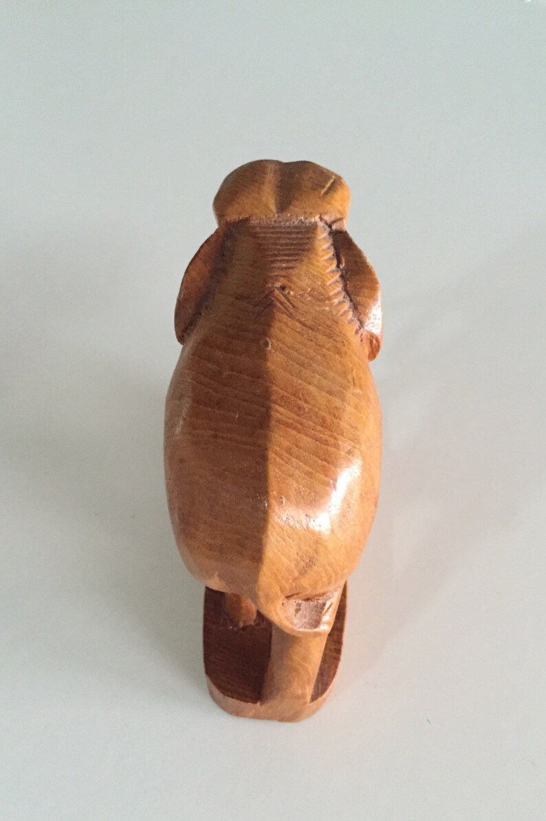 May include: A wooden elephant figurine carved in a standing position. The elephant is made of light brown wood and has a smooth, polished finish.