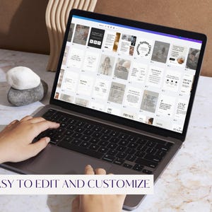 May include: A laptop displaying a design interface with various templates. The screen shows multiple layouts with text and images. The text "EASY TO EDIT AND CUSTOMIZE" is at the bottom of the screen. A stack of stones and a wooden decorative piece are on the table.