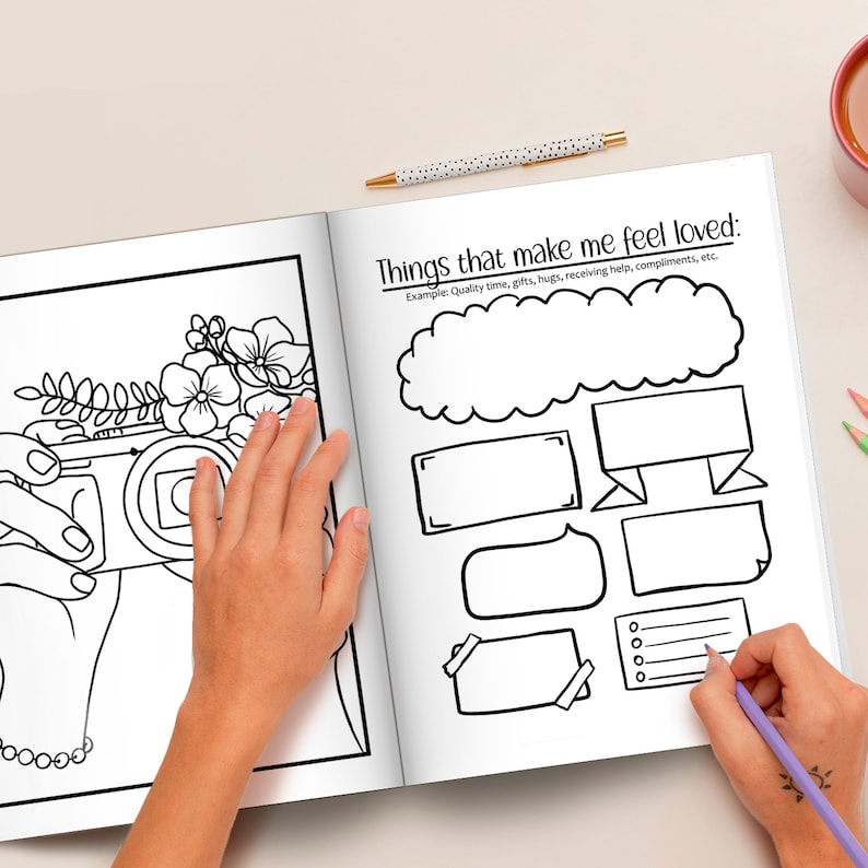 May include: A black and white colouring book page with a drawing of a camera and flowers. The page is open to a spread that includes the text "Things that make me feel loved:" and several blank shapes for writing.