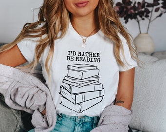 May include: A white t-shirt with the text "I'd rather be reading" and a black and white illustration of a stack of books.