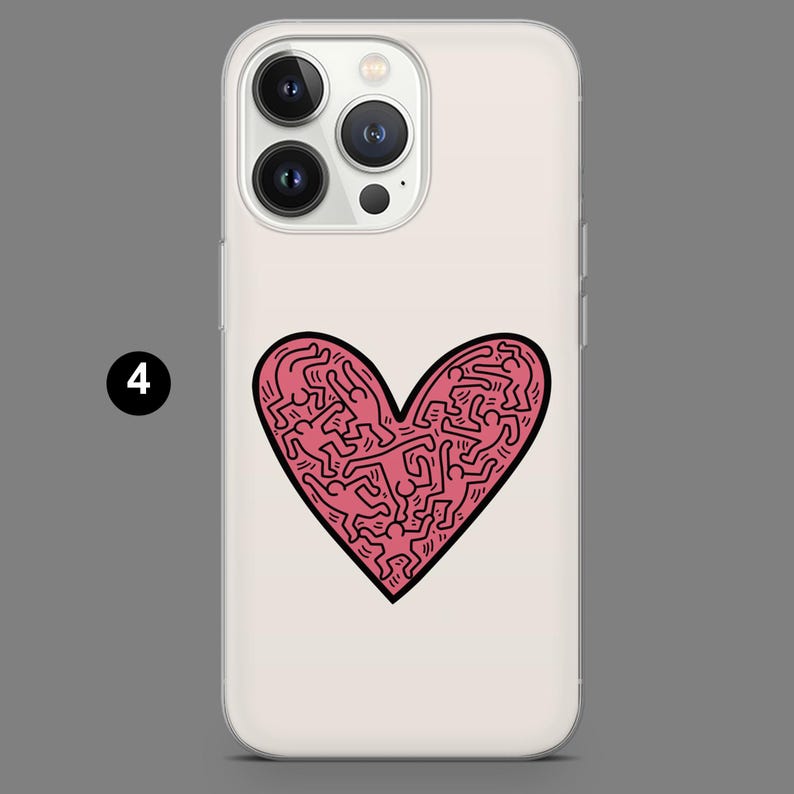 May include: A clear phone case featuring a pink heart design filled with abstract figures. The heart is outlined in black and set against a white background. The phone case has a glossy finish and a camera bump.