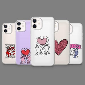 May include: A collection of phone cases with various designs. The cases feature pop art illustrations, including hearts, dancing figures, and abstract patterns in red, pink, and black on a white or colored background. The cases are displayed against a gray backdrop.