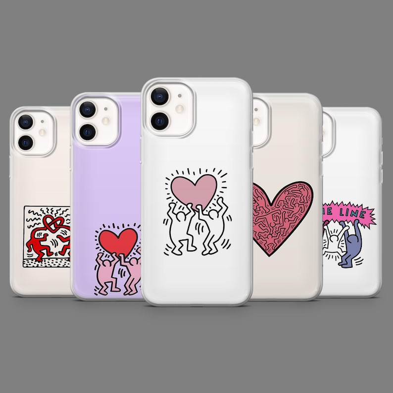 May include: A collection of phone cases with various designs. The cases feature pop art illustrations, including hearts, dancing figures, and abstract patterns in red, pink, and black on a white or colored background. The cases are displayed against a gray backdrop.