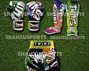 Peut inclure: Un ensemble d'équipement de Muay Thai comprenant deux gants de boxe, deux protège-tibias et un short. Les articles sont décorés de motifs style graffiti en vert, bleu, orange et blanc, et toutes les pièces affichent le texte TWINS SPECIAL.