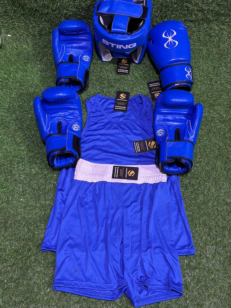 May include: A complete blue boxing set, including gloves, headgear, a tank top, and shorts. The gloves have a white spider web design. The headgear has the word "STING" printed on it. The shorts have a white waistband.