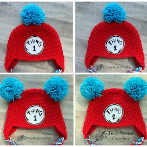 May include: Two red crocheted hats with blue pom-poms. One hat has a white circle with "THING 1" in black text. The other hat has a white circle with "THING 2" in black text.
