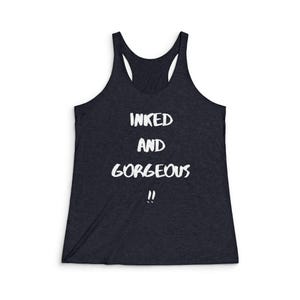 May include: A dark blue tank top with the text "INKED AND GORGEOUS" in white lettering.