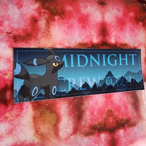May include: A rectangular sticker featuring a black Umbreon character with blue accents, set against a night sky backdrop. The sticker reads "MIDNIGHT CREW" in white text, with Japanese characters below. The background is a watercolor wash of red and pink.