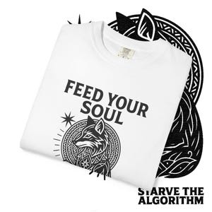 May include: White t-shirt featuring the words "FEED YOUR SOUL" in black, with a black and white fox illustration. The phrase "STARVE THE ALGORITHM" is printed at the bottom of the shirt.