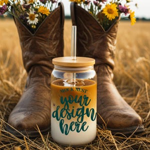 May include: A clear glass tumbler with a bamboo lid and straw, featuring the text "MOCK NEST your design here." The tumbler is filled with a layered drink. Brown cowboy boots with flowers in them are in the background.