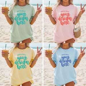 May include: Four pastel-colored t-shirts with the text "MOCK NEST your design here". The shirts are light green, pink, yellow, and blue. Each person is holding a beverage with a straw and making a peace sign.