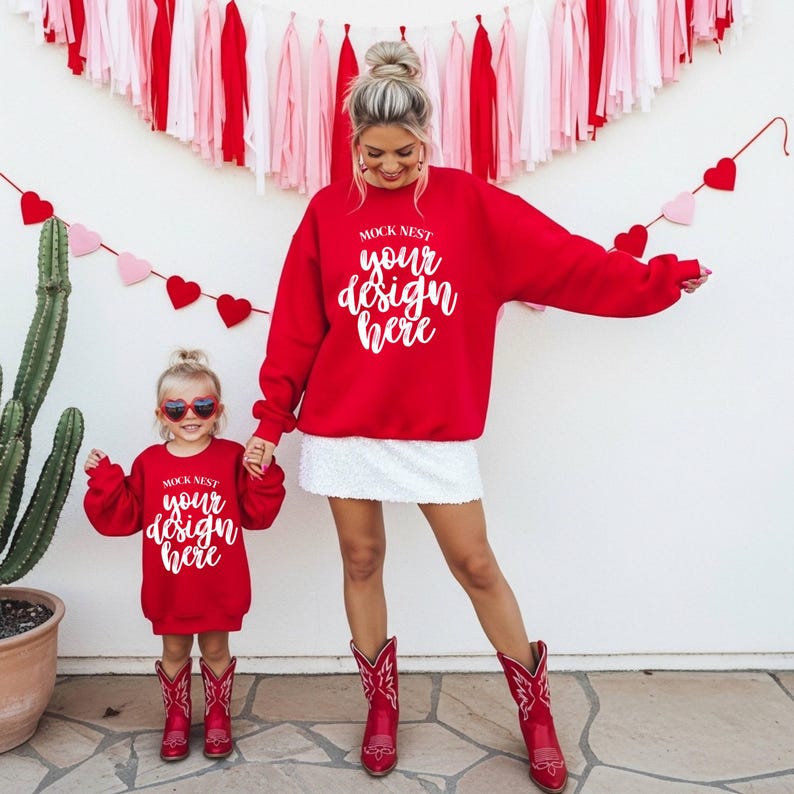 May include: A mother and child wearing matching red sweatshirts with the text "MOCK NEST your design here". The mother is wearing a white skirt and red cowboy boots. The child is wearing red heart-shaped sunglasses and red cowboy boots.