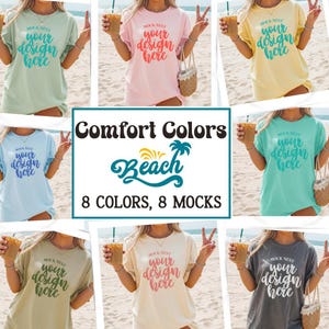 May include: A collection of eight t-shirts in various colors, each featuring the text "your design here" in a script font. The image also includes the text "Comfort Colors Beach 8 Colors, 8 Mocks". The shirts are displayed on a beach setting.