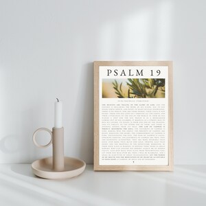 Puede incluir: Una impresión enmarcada con el texto "PSALM 19" y una imagen botánica. La impresión está en un marco de madera clara y está acompañada por un candelabro beige con una vela blanca.