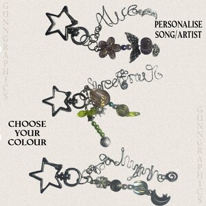 May include: Three decorative keychains featuring black star-shaped clasps, wire-formed names or words, and assorted beads including flowers, moons, and spheres. The text reads PERSONALISE SONG/ARTIST and CHOOSE YOUR COLOUR. Each keychain has a unique arrangement of charms and beads attached to a dark metal chain.