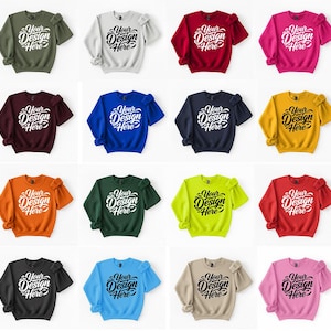 May include: A collection of crewneck sweatshirts in various colors, including green, white, red, and pink. Each sweatshirt features the text "Your Design Here" in a stylized font. The sweatshirts are displayed with their sleeves rolled up.