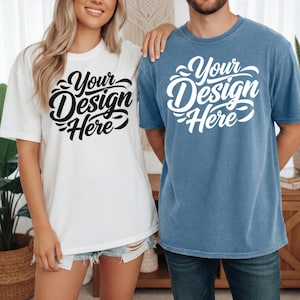 May include: Two short-sleeved t-shirts, one white and one blue, with the text "Your Design Here" in a black and white script. The white shirt is worn with denim shorts. The blue shirt is worn with blue jeans.