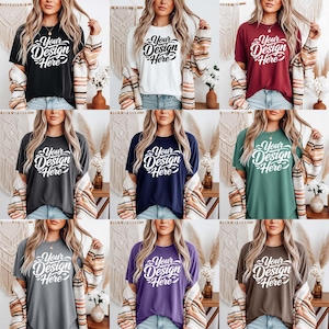 May include: Nine different coloured t-shirts, including black, white, burgundy, charcoal, navy, green, grey, purple, and brown. Each shirt has the text "Your Design Here" in a white, cursive font. The shirts are modelled.
