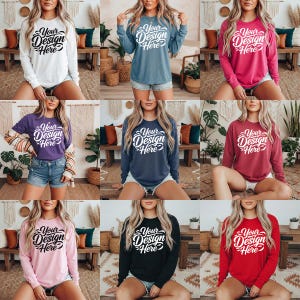 May include: A selection of long-sleeved sweatshirts in a range of colours: white, blue, pink, purple, navy, burgundy, black, and red. Each top displays the text "Your Design Here" in a cursive font.