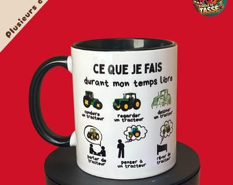May include: White ceramic mug with a black handle and rim, featuring the text "CE QUE JE FAIS durant mon temps libre" and illustrations of tractors. The mug has a red background and a cartoon logo.