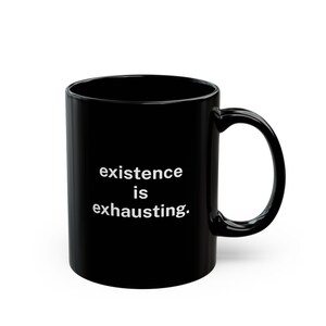 Könnte beinhalten: Schwarze Keramik-Kaffeetasse mit weißem Text, der "existence is exhausting." lautet.