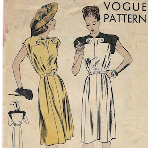 May include: A vintage Vogue Pattern envelope, number 5482, size 18, featuring illustrations of two dresses with belted waists and button details. One dress is yellow, the other is white with dark shoulders. Text includes VOGUE PATTERN, SIZE 18, 36 BUST 39 HIP.